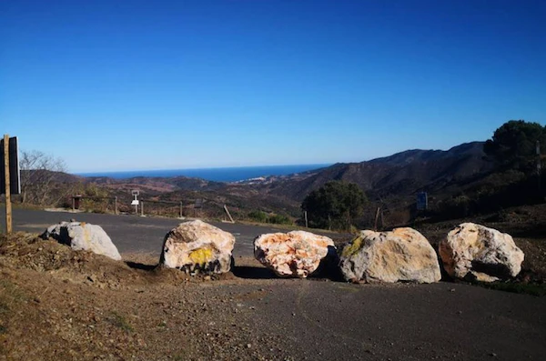 Dans la pratique, piétons, vélos et même certains véhicules peuvent passer par le col, malgré les rochers érigés en travers de la route (fournie)