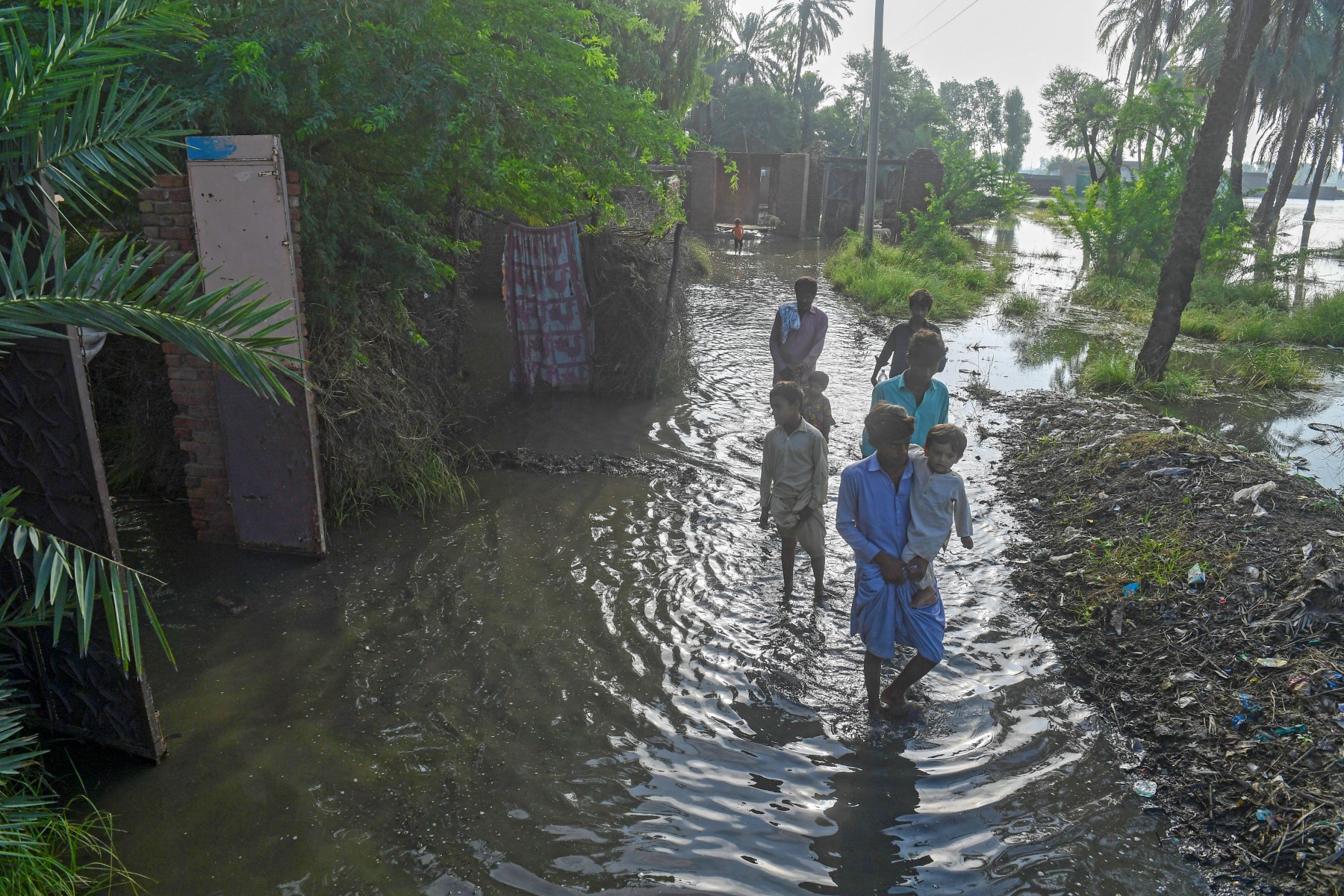 Des habitants touchés par les inondations traversent une rue à Sukkur, dans la province du Sindh, le 2 septembre 2022. (Photo par Asif HASSAN / AFP)