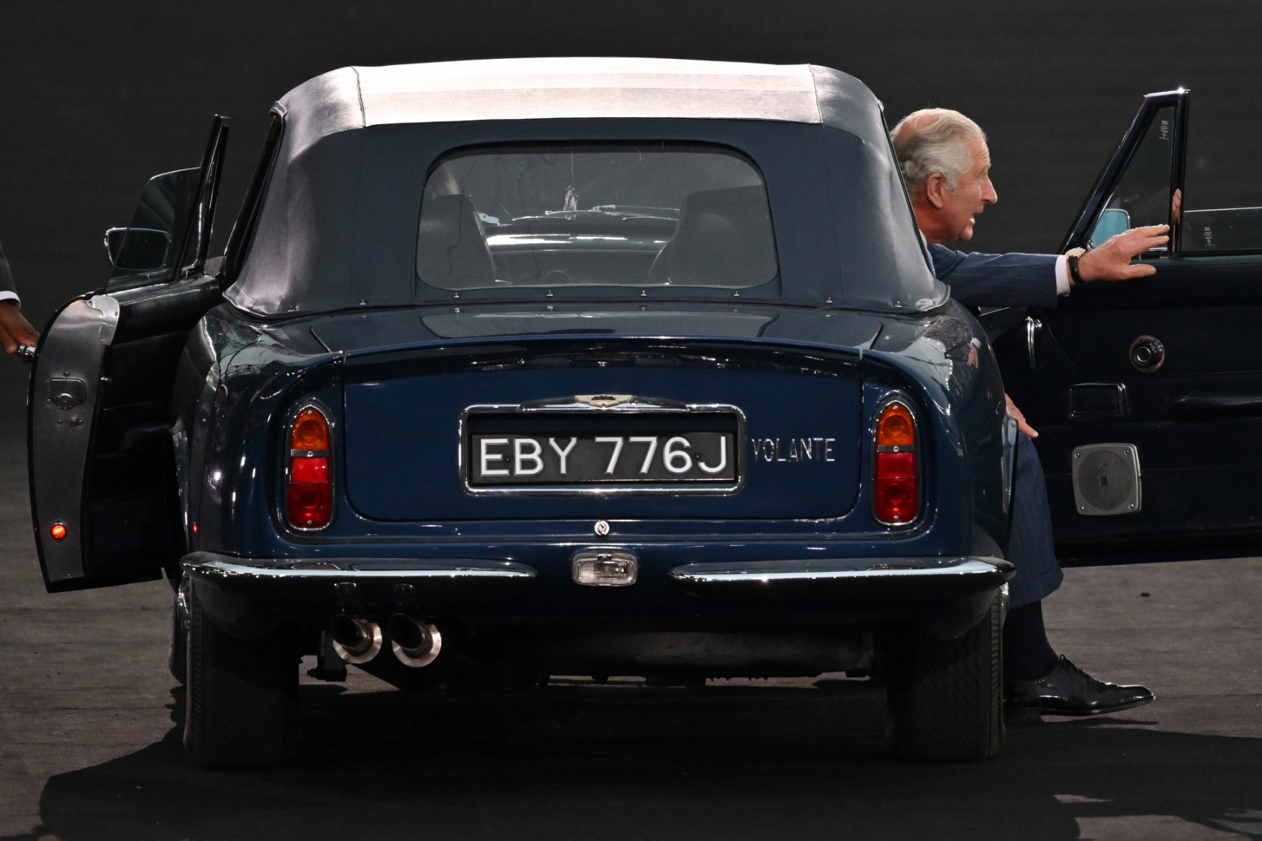 Sur cette photo d'archive prise le 28 juillet 2022, le prince Charles, prince de Galles, et Camilla, duchesse de Cornouailles (non vue), arrivent au volant d'une Aston Martin pour la cérémonie d'ouverture des Jeux du Commonwealth, au stade Alexander de Birmingham, dans le centre de l'Angleterre. (Photo par Glyn KIRK / AFP)