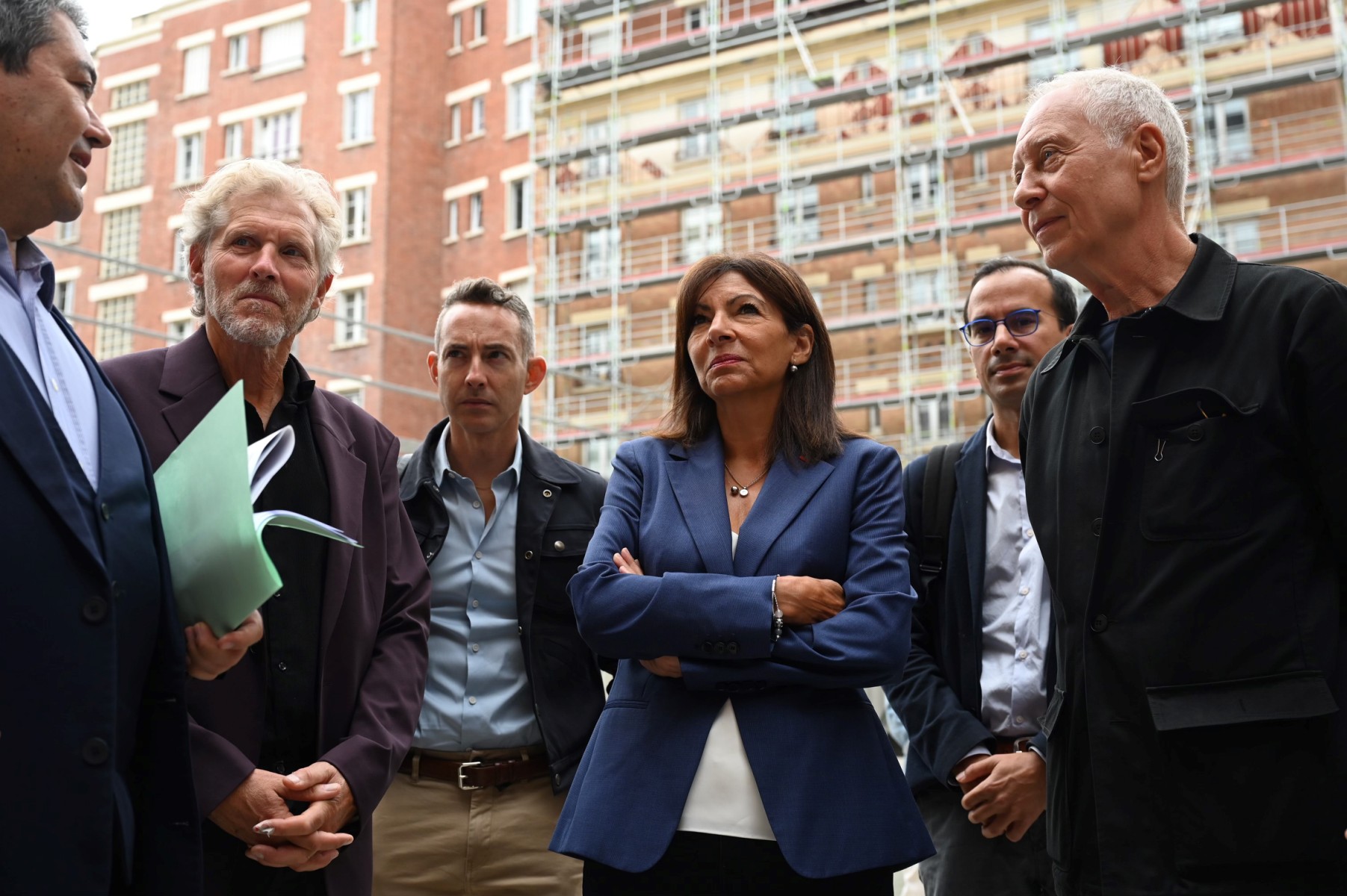 La maire de Paris, Anne Hidalgo (au centre), s'entretient avec le maire du 13e arrondissement, Jérôme Coumet, aux côtés des adjoints au maire, Ian Brossat (3e à gauche) et Dan Lert (2e à droite), et de l'architecte Philippe Roux (à droite), alors qu'elle visite un chantier de réhabilitation énergétique d'un immeuble, le 13 septembre 2022. (Photo par Emmanuel Dunand / AFP)