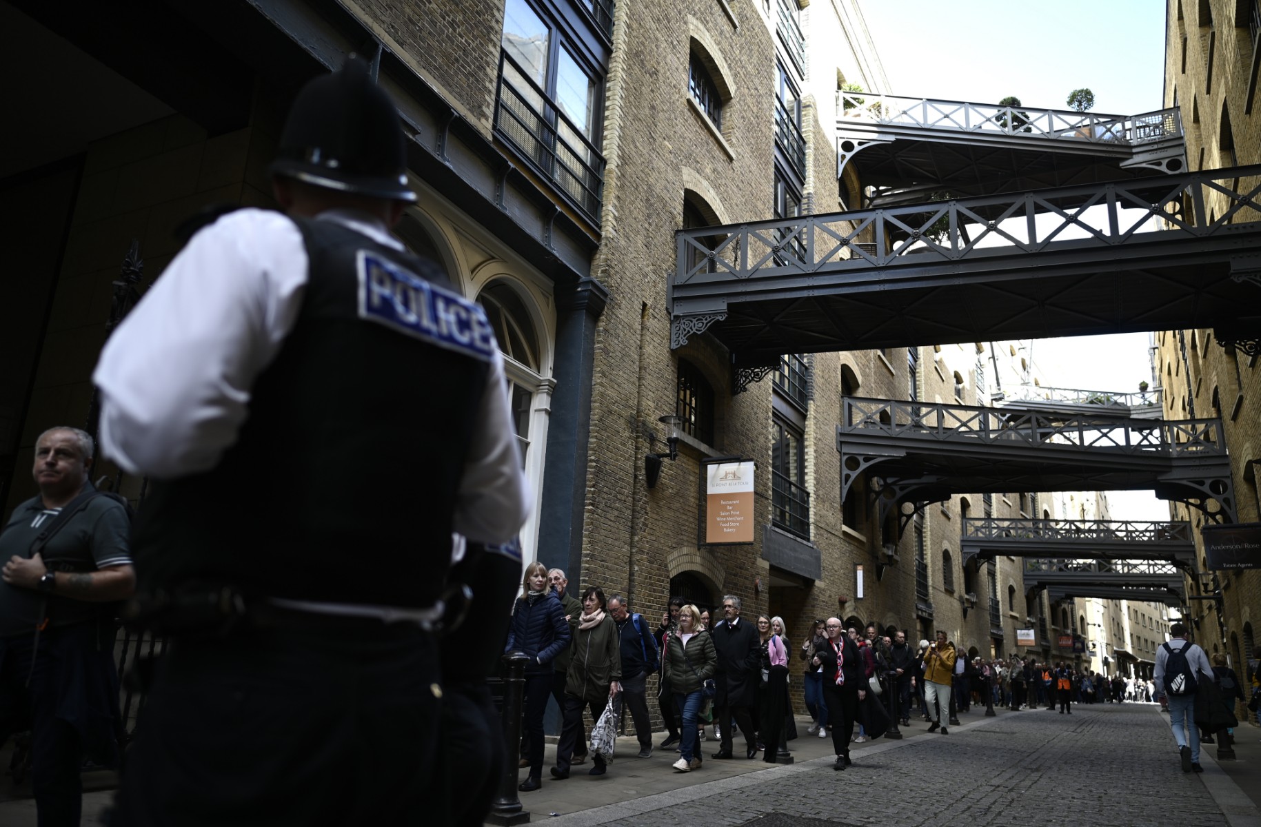 Des membres du public près du Tower Bridge, alors qu'ils font la queue pour rendre hommage à la défunte reine Elizabeth II, à Londres, le 16 septembre 2022. (Photo de Loic Venance / AFP)