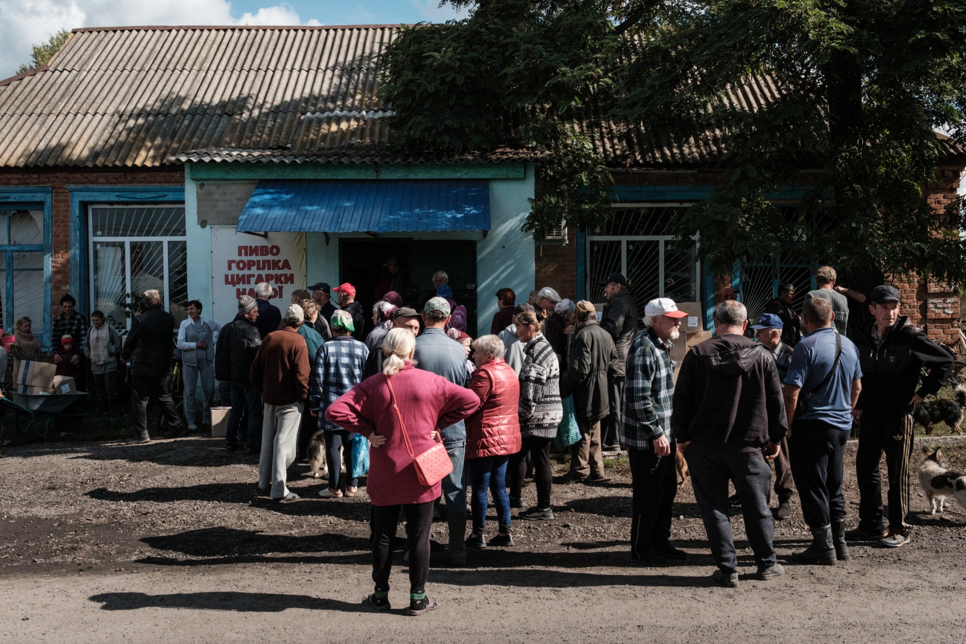 Des habitants attendent de recevoir des boîtes contenant 12 kilos (26 livres) de denrées alimentaires de base, soit assez pour nourrir une personne pendant un mois, lors d'une distribution de rations alimentaires dans un magasin de l'ancien village de la ligne de front de Lebyazhe, le 22 septembre 2022. (Photo de Yasuyoshi Chiba / AFP)