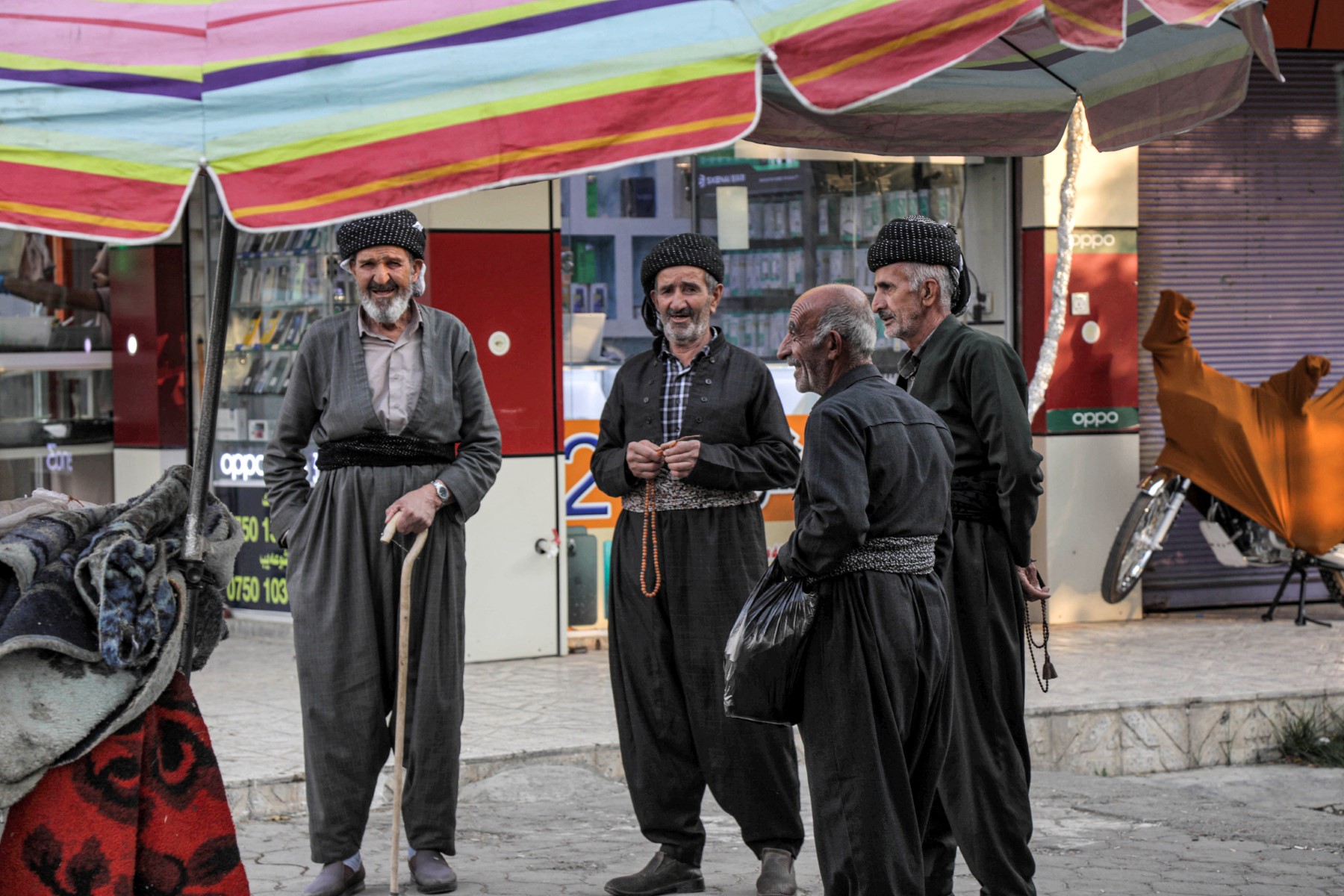 Des hommes kurdes irakiens vêtus de vêtements traditionnels se tiennent le long d'une rue dans le district de Penjwen, dans la région autonome du Kurdistan irakien, le 22 septembre 2022. (Photo : Safin Hamed / AFP)