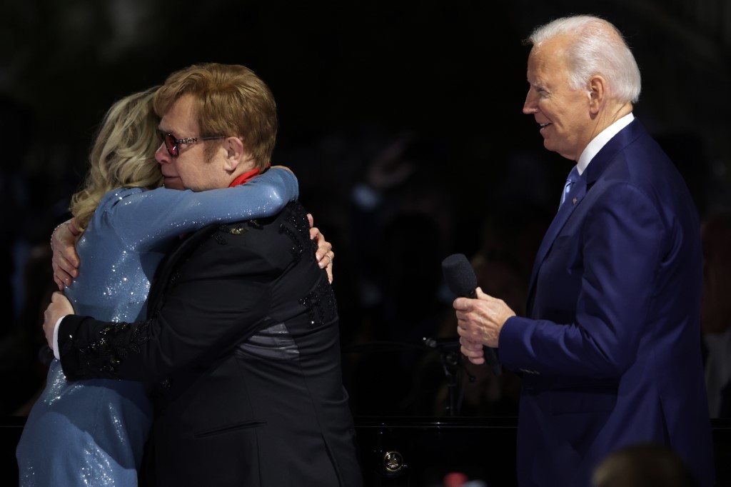L'auteur-compositeur-interprète britannique Sir Elton John (2e à gauche) embrasse la première dame des États-Unis Jill Biden (à gauche) après que le président Joe Biden (à droite) lui a remis la Médaille nationale des sciences humaines lors d'un événement sur la pelouse sud de la Maison-Blanche, le 23 septembre 2022 à Washington. (Photo Par Alex Wong / Getty Images North America / Getty Images via AFP)