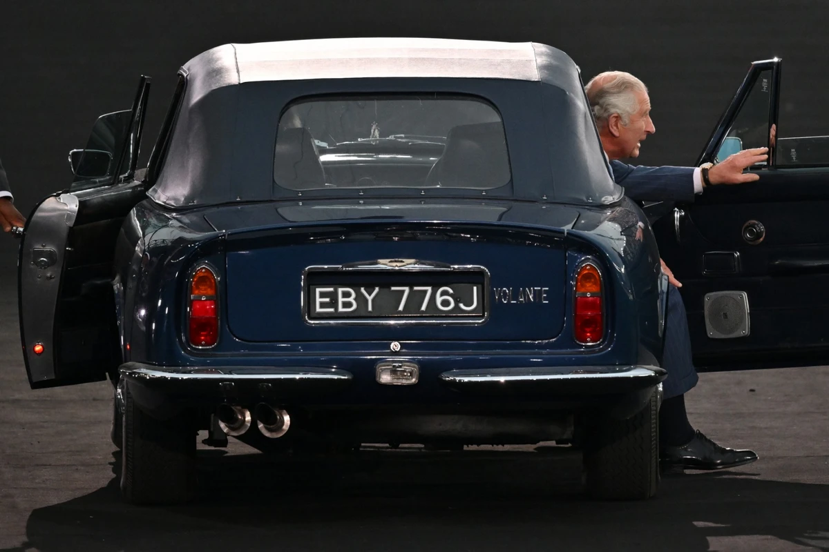 Sur cette photo d'archive prise le 28 juillet 2022, le prince Charles, prince de Galles, et Camilla, duchesse de Cornouailles (non vue), arrivent au volant d'une Aston Martin pour la cérémonie d'ouverture des Jeux du Commonwealth, au stade Alexander de Birmingham, dans le centre de l'Angleterre. (Photo par Glyn KIRK / AFP)