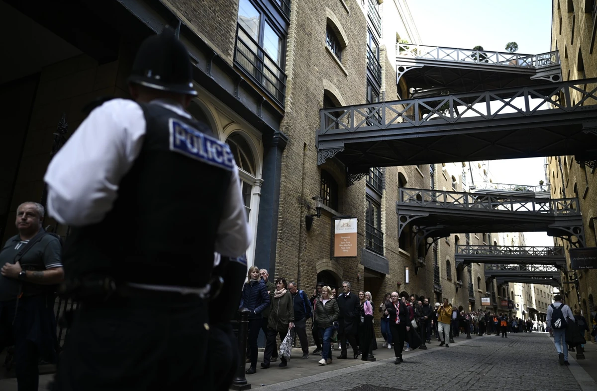 Des membres du public près du Tower Bridge, alors qu'ils font la queue pour rendre hommage à la défunte reine Elizabeth II, à Londres, le 16 septembre 2022. (Photo de Loic Venance / AFP)