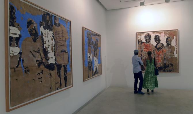 Un couple regarde les œuvres du peintre ivoirien Armand Boua exposées à la galerie Cecile Fakhoury à Abidjan le 23 août 2019. (AFP)