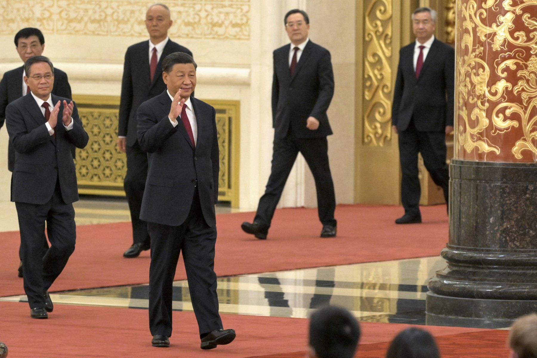 Le président chinois Xi Jinping (devant) marche avec les membres du nouveau Comité permanent du Politburo du Parti communiste chinois, l'organe décisionnel suprême de la nation, dont Li Qiang (devant à gauche), alors qu'ils rencontrent les médias dans le Grand Hall du Peuple à Pékin, le 23 octobre 2022. (Photo de WANG Zhao / AFP)
