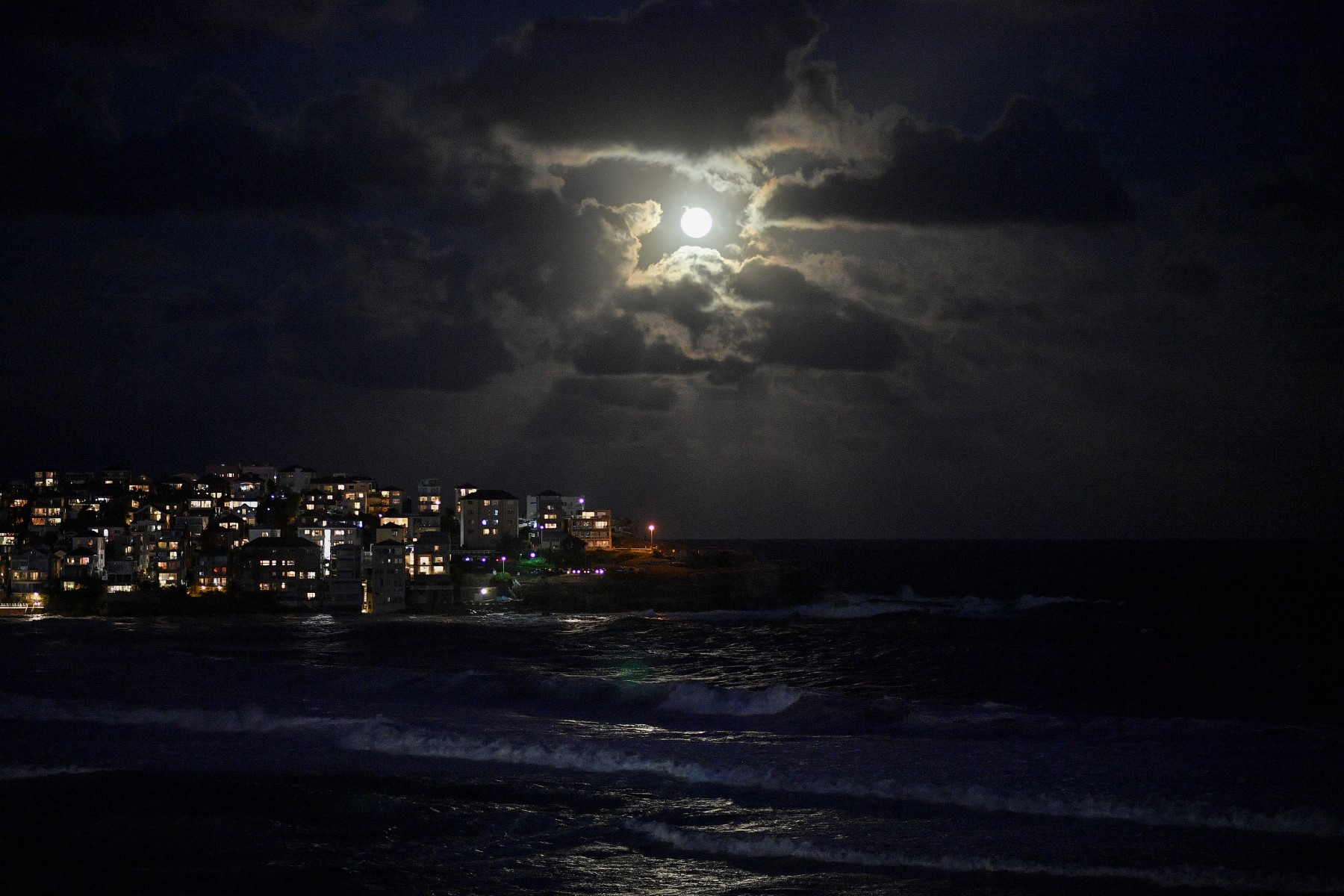 La pleine lune se lève sur la plage de Bondi à Sydney, le 21 septembre 2021. (Photo de Saeed KHAN / AFP)