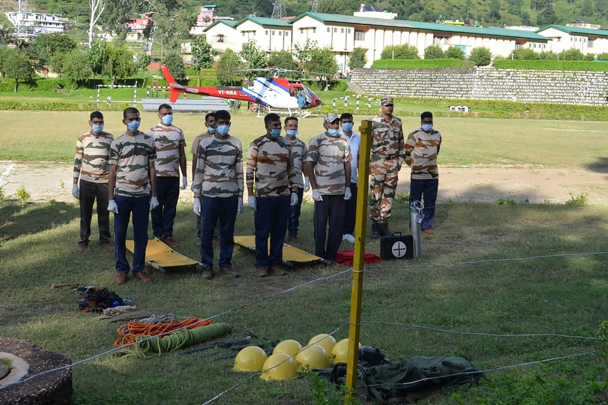 Le personnel de la police frontalière indo-tibétaine (ITBP) se tient en position pendant les préparatifs d'une opération de sauvetage d'alpinistes disparus, victimes d'une avalanche, à l'héliport de l'ITBP à Matli, le 5 octobre 2022. (Photo de la police frontalière indo-tibétaine (ITBP) / AFP)