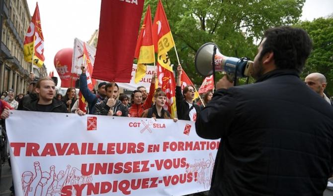 Des membres du syndicat des étudiants, lycéens et apprentis «SELA» tiennent une banderole lors du rassemblement du 1er mai 2022 (fête du travail) à Toulouse. (AFP)