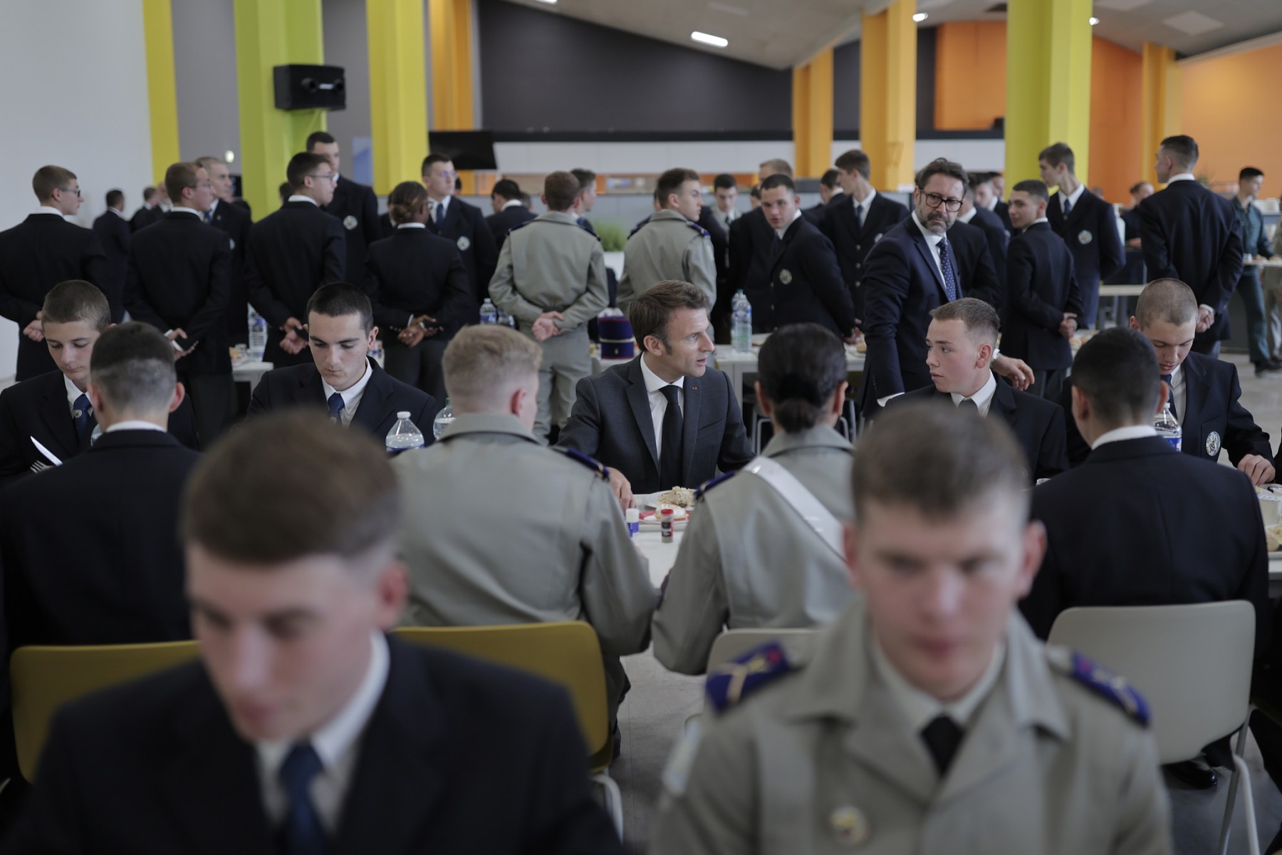 Le président français Emmanuel Macron (au centre) partage un déjeuner avec des cadets dans une école militaire le 27 octobre 2022 à Bourges, dans le centre de la France, dans le cadre d'une visite axée sur les armées et l'industrie de l'armement françaises. (Photo de Lewis Joly / Pool / AFP)