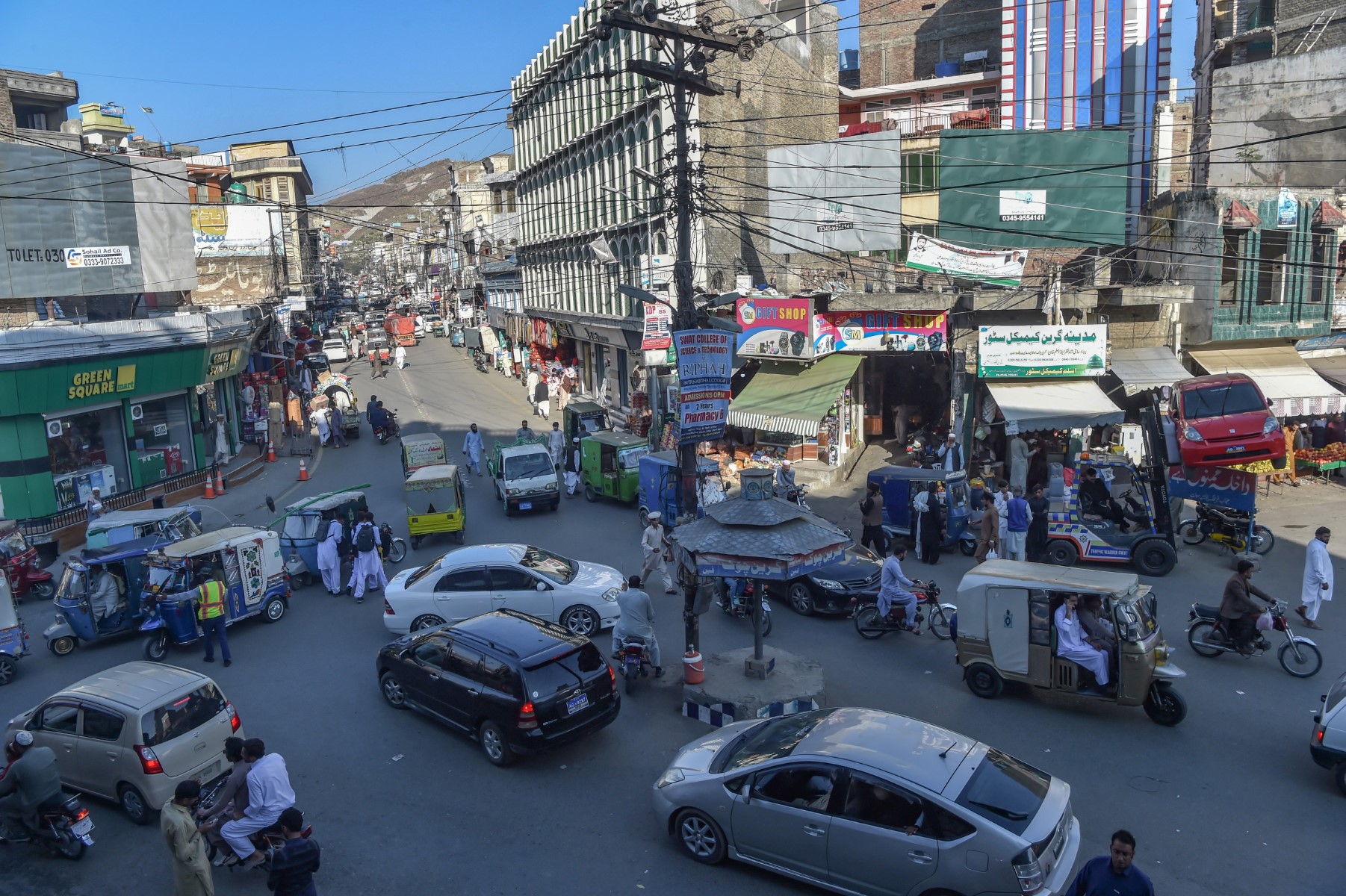 Sur cette photo prise le 25 octobre 2022, des habitants de la banlieue empruntent une route très fréquentée dans un marché de Mingora, dans le district de Swat (Khyber Pakhtunkhwa). (Photo par Abdul MAJEED / AFP)