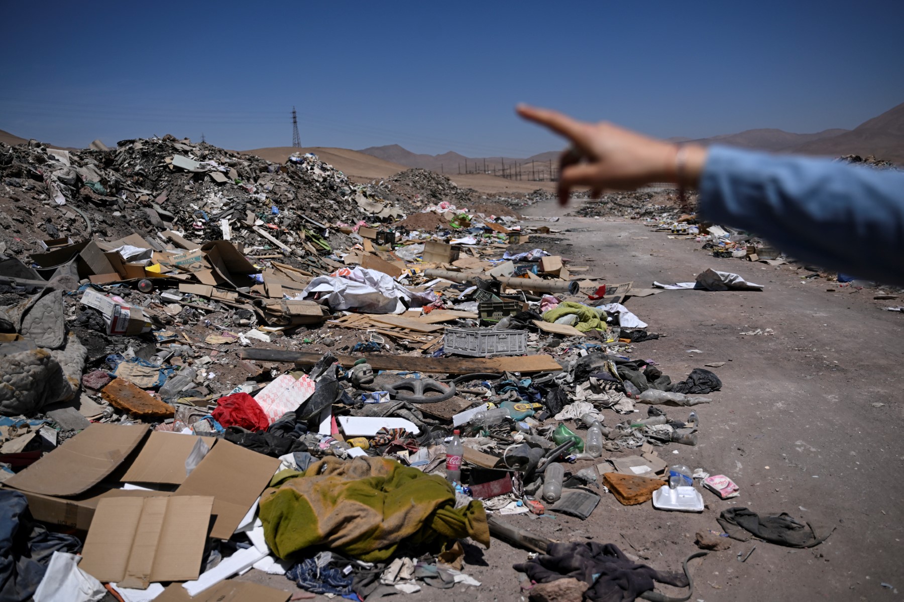 L'avocate Paulina Silva montre des vêtements jetés dans le désert, dans le secteur La Pampa de l'Alto Hospicio, à environ 10 km à l'est de la ville d'Iquique, au Chili, le 11 novembre 2022. (Photo : Martin Bernetti / AFP)