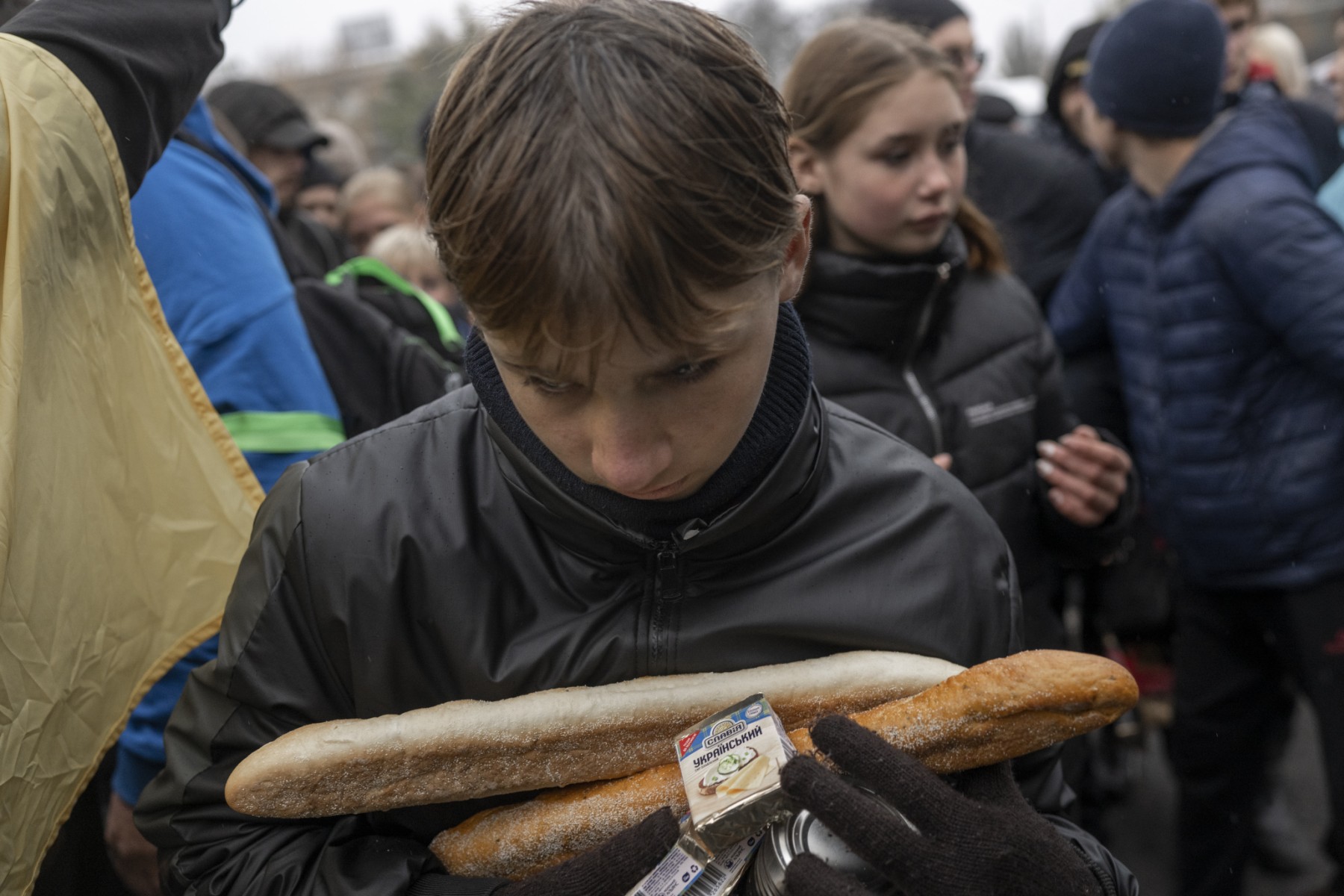 Un garçon tient dans ses mains des vivres de secours qu'il a reçus dans le centre de Kherson, le 17 novembre 2022. (Photo par Bulent Kilic / AFP)