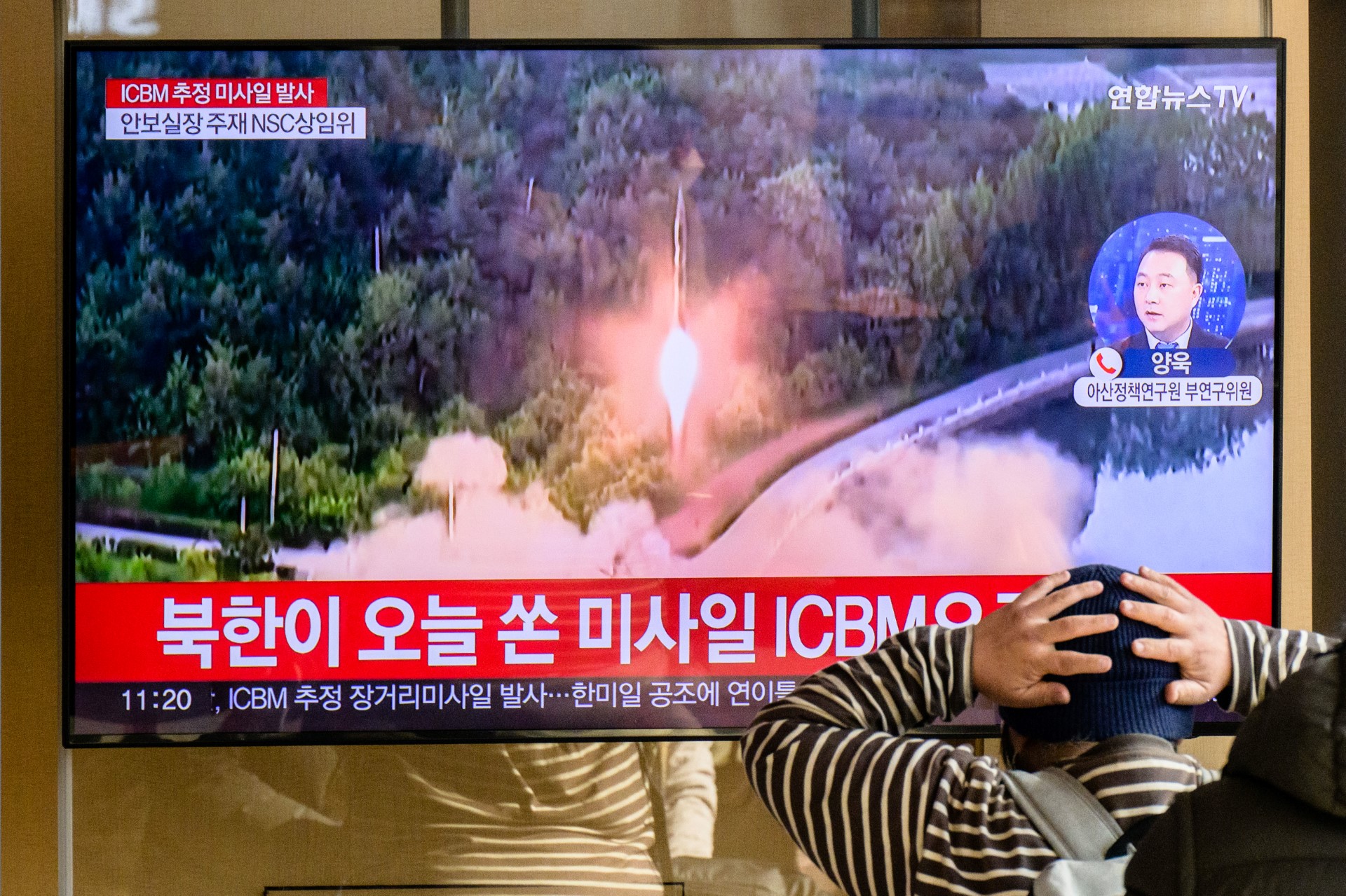Un homme regarde un journal télévisé avec des images d'archives d'un essai de missile nord-coréen, dans une gare de Séoul, le 18 novembre 2022. (Photo : Anthony Wallace / AFP)