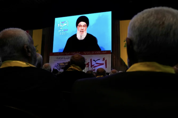 Des partisans du Hezbollah affichent des photos de leurs proches, morts au combat, pendant qu’ils écoutent un discours du chef du Hezbollah Sayyed Hassan Nasrallah lors d’un rassemblement le 11 novembre 2022. (AP)