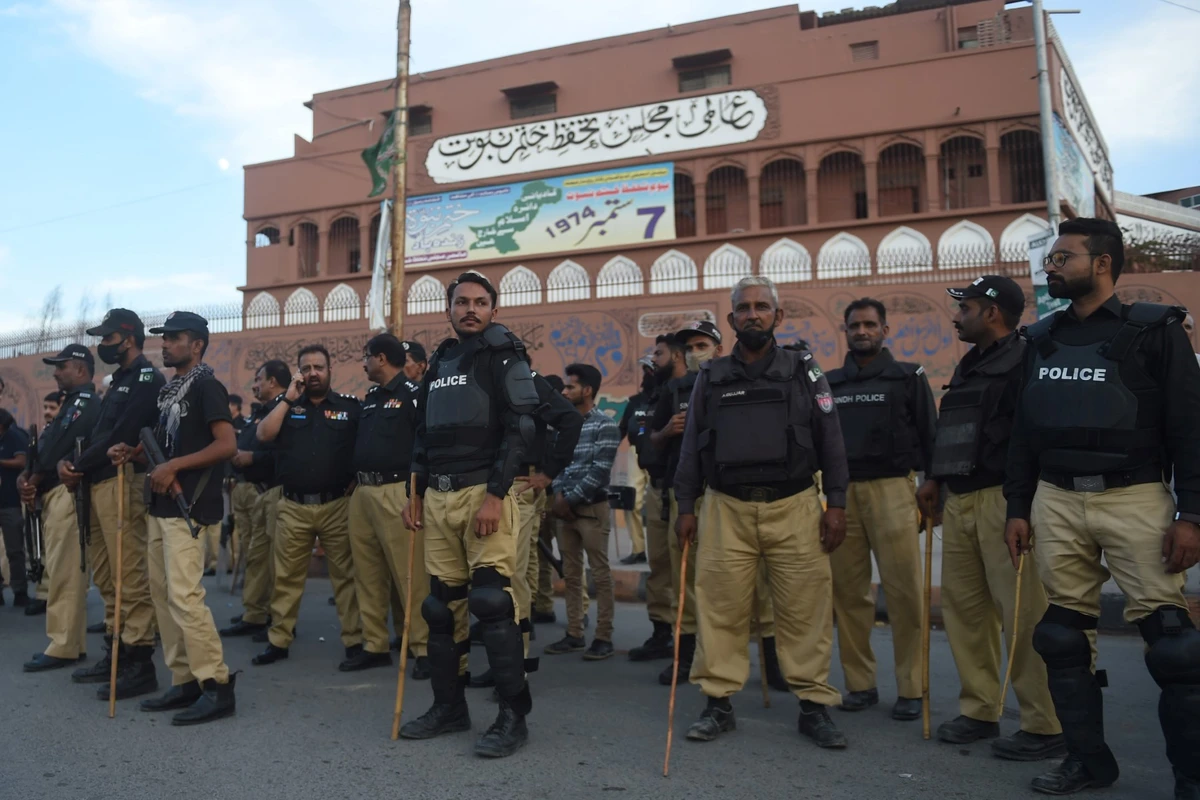 Des policiers montent la garde lors d'une manifestation de partisans de l'ancien Premier ministre pakistanais Imran Khan contre la tentative d'assassinat dont il a été victime, à Karachi, le 5 novembre 2022. (Photo de Rizwan Tabassum / AFP)