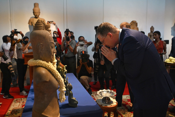 Le secrétaire d'État adjoint américain aux affaires de l'Asie de l'Est et du Pacifique, Daniel J. Kritenbrink (à droite), fait un geste devant des statues lors d'une cérémonie de rapatriement de 27 objets pillés restitués au Cambodge au Musée national de Phnom Penh, le 13 juillet 2022. (Photo de Tang Chhin Sothy / AFP)