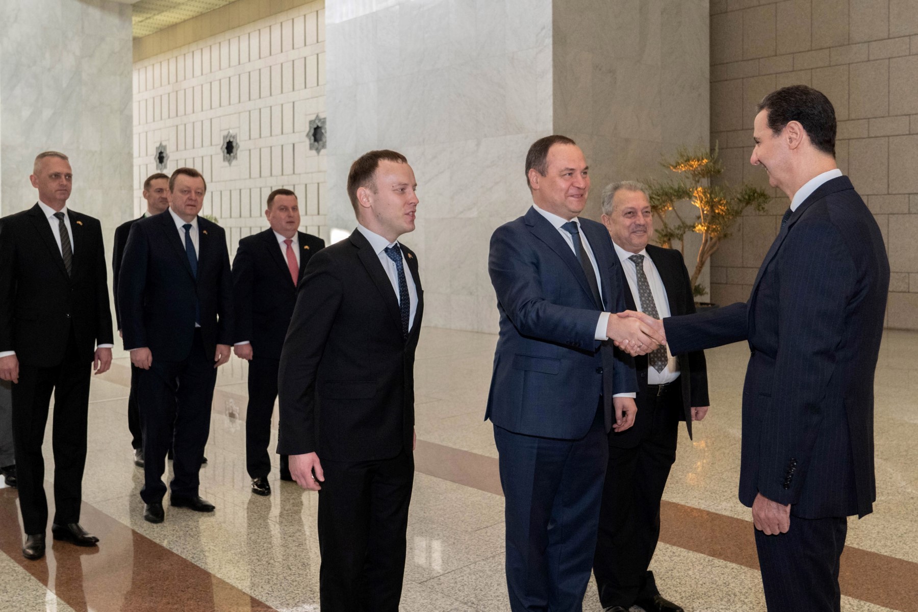 Une photo publiée par l'agence officielle Syrian Arab News Agency (SANA) le 24 novembre 2022 montre le président syrien Bashar al-Assad (à droite) accueillant le premier ministre du Belarus Roman Golovchenko à Damas. (Photo par SANA / AFP)