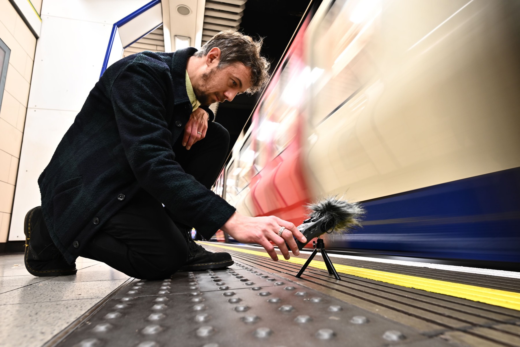 Le musicien et artiste sonore Stuart Fowkes enregistre le son du passage d'une rame du métro londonien à la station de métro Blackfriars, à Londres, le 28 novembre 2022. (Photo : Ben Stansall / AFP)
