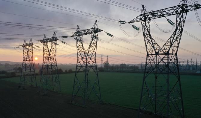 Une vue aérienne de pylônes électriques au coucher du soleil dans la campagne de Saint-Laurent-de-Terregatte, dans l'ouest de la France, le 6 décembre 2022. (Photo de Damien MEYER / AFP)