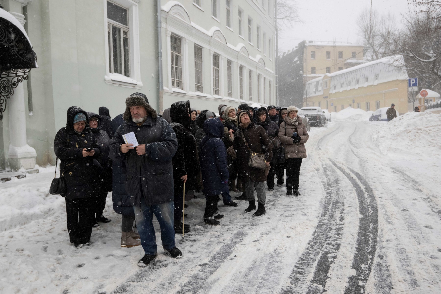 Un groupe de touristes visite la ville pendant de fortes chutes de neige dans le centre de Moscou, le 18 décembre 2022. (Photo de Natalia Kolesnikova / AFP)