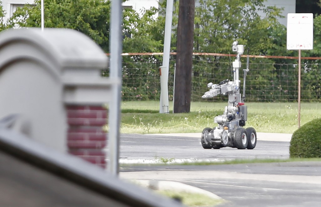La police de Dallas utilise un robot pour accéder à un fourgon blindé, dont les autorités pensent qu'il était truffé d'explosifs, et qui était conduit par un suspect qui a attaqué le quartier général de la police de Dallas, au Texas, le 13 juin 2015. (Photo par Stewart F. House / Getty Images North America / Getty Images via AFP)