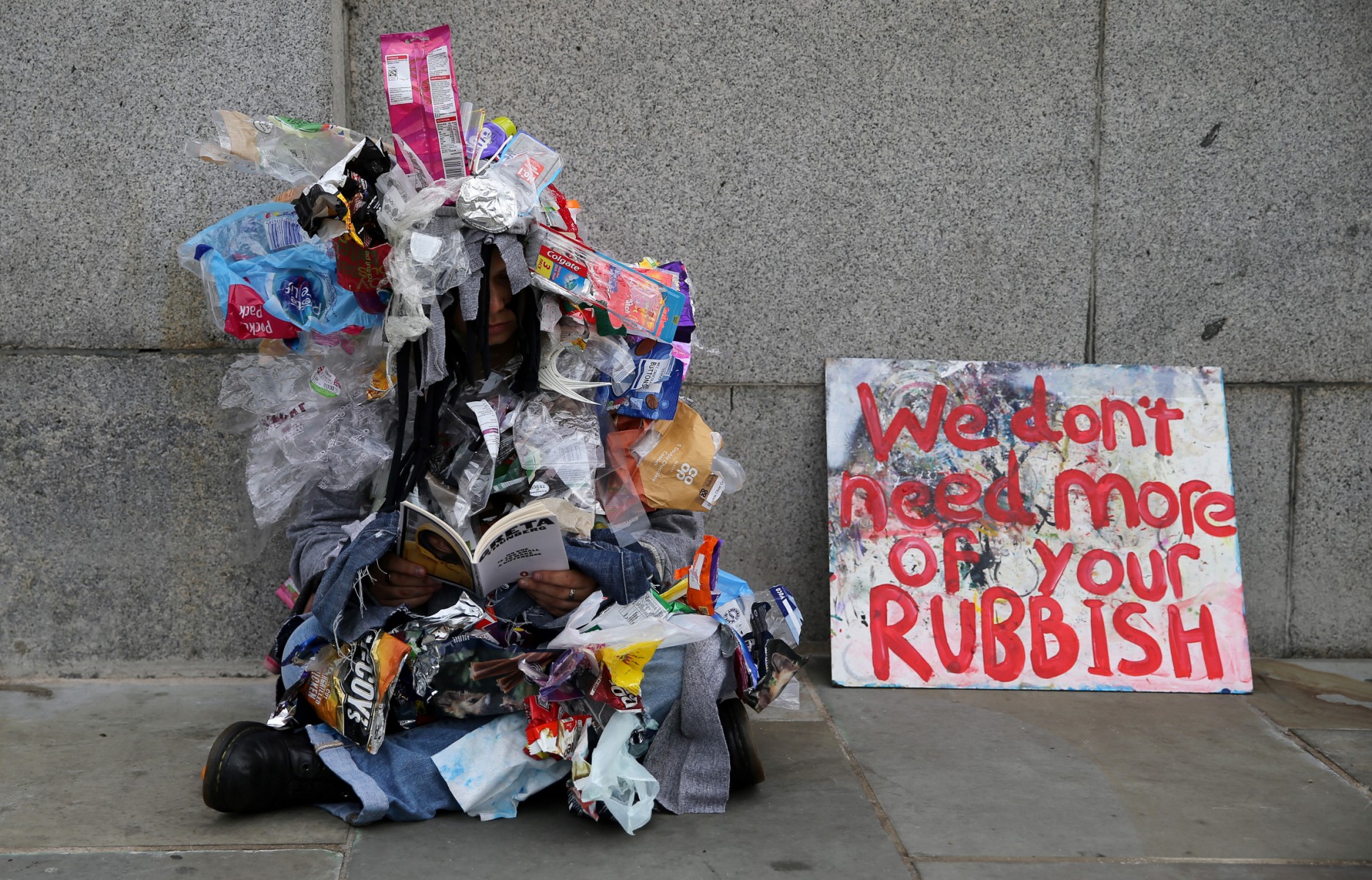 Un militant du changement climatique du groupe Extinction Rebellion, habillé d'emballages plastiques à usage unique, manifeste devant les Chambres du Parlement, dans le centre de Londres, le 7 octobre 2019. (AFP / Isabel Infantes)