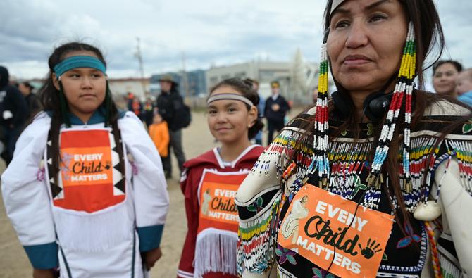 Des femmes autochtones portant sur leurs vêtements l'inscription "Every Child Matters" attendent l'arrivée du pape François à l'école Nakasuk à Iqaluit, Nunavut, Canada, le 29 juillet 2022. (AFP).