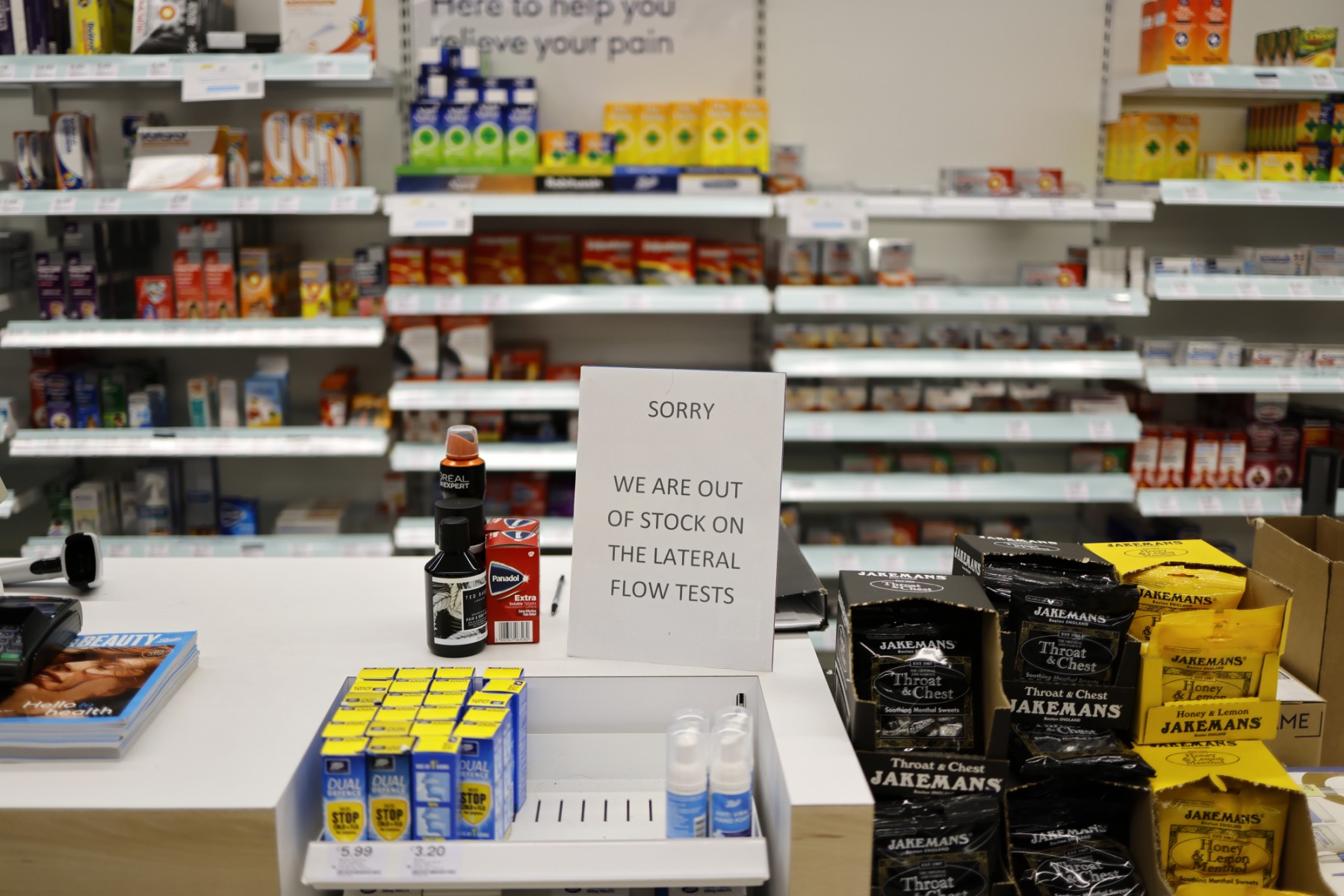 Un panneau sur le comptoir d'une pharmacie informe les clients que la pharmacie est en rupture de stock de tests antigéniques Covid-19 Lateral Flow (LFT) fournis par le gouvernement, dans le nord-est de Londres, le 3 janvier 2022. (Photo de Tolga Akmen / AFP)
