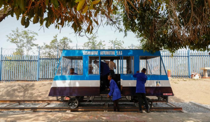 Des élèves du lycée technique de Soshanguve nettoient un train à énergie solaire qu’ils ont eux-mêmes construit à Pretoria. (AFP)