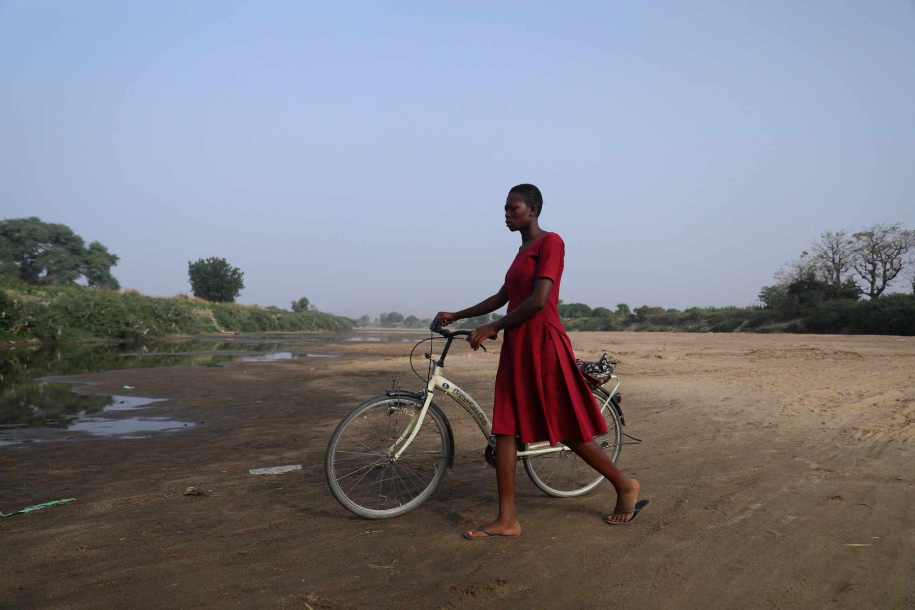 Une femme traverse le lit asséché de la Volta blanche vers le Burkina Faso depuis Issakateng-Bausi, à Bawku, dans le nord du Ghana, le 7 décembre 2022. (Photo de Nipah Dennis / AFP)