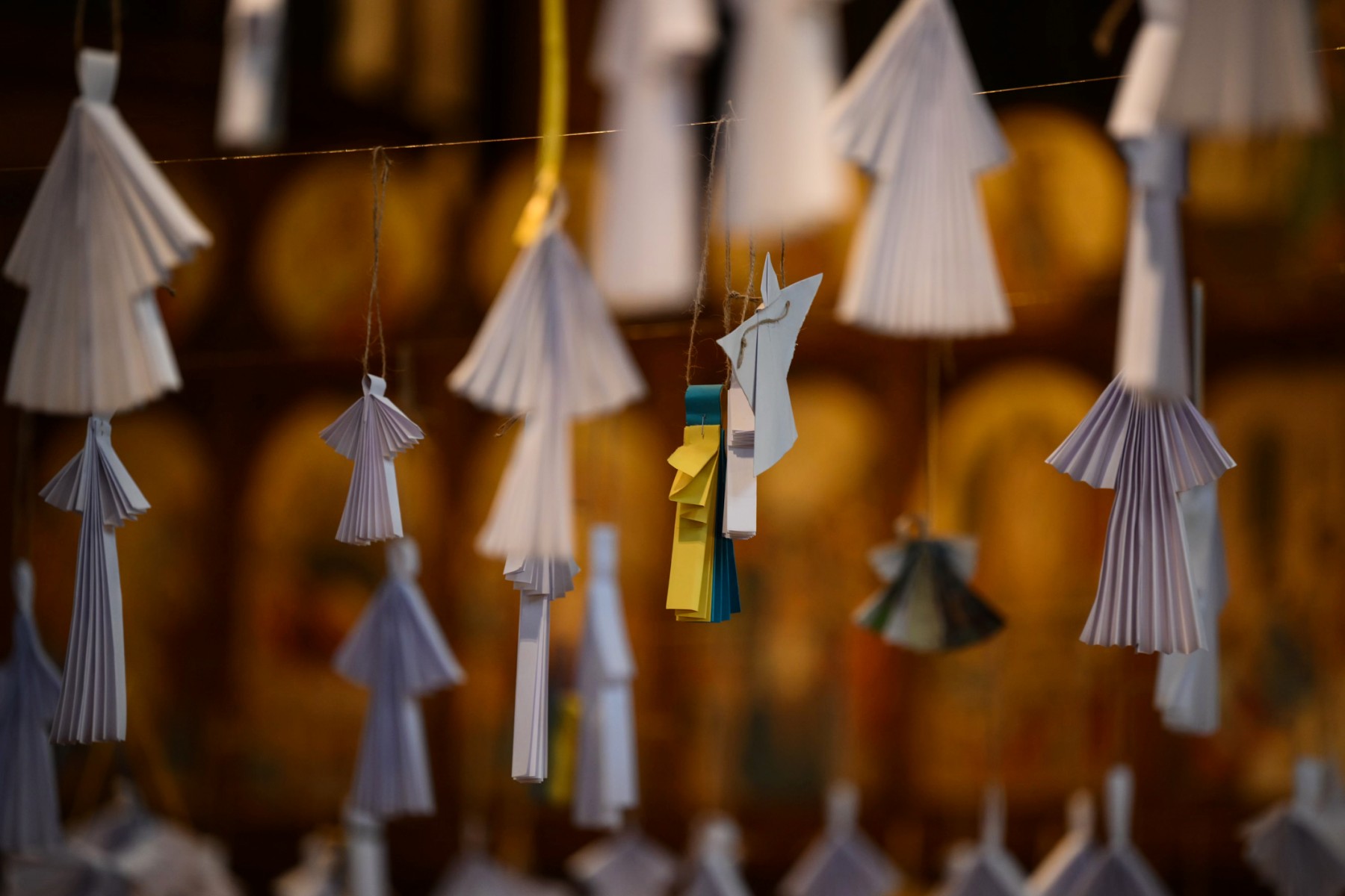 Un ange en papier représentant les couleurs nationales de l'Ukraine est photographié parmi les 461 anges en papier, un pour chaque enfant décédé au cours de l'année écoulée selon les statistiques officielles, exposés lors du service de prière œcuménique à la cathédrale catholique ukrainienne, à Londres, le 24 février 2023, date du premier anniversaire de l'invasion de l'Ukraine par la Russie. (Photo de Daniel LEAL / AFP)