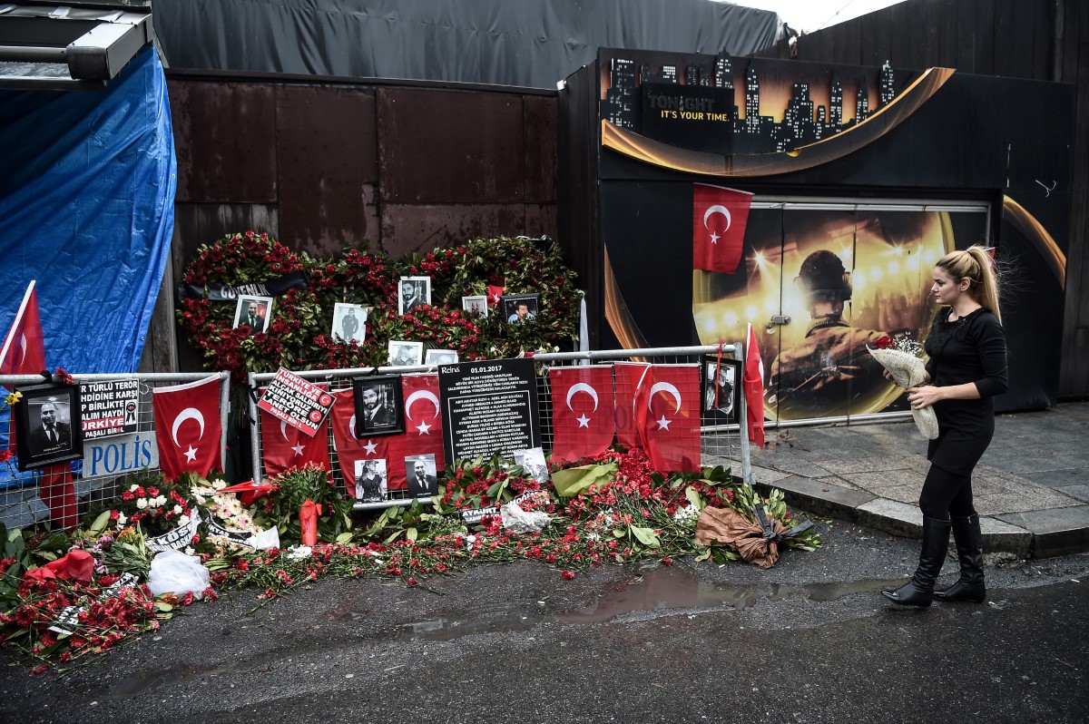Une femme dépose des fleurs près d'un mémorial de fortune devant la boîte de nuit Reina à Istanbul, le 17 janvier 2017, un jour après que la police turque a arrêté l'assaillant présumé. (Photo par Ozan Kose / AFP)