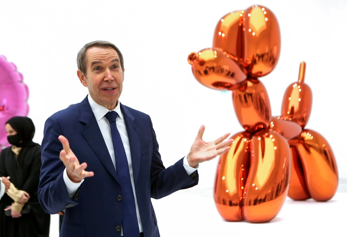 L'artiste américain Jeff Koons devant son Balloon Dog à la galerie Alriwaq du Qatar Museum, à Doha, le 20 novembre 2021. (Photo : Patrick Baz / Musée du Qatar / AFP)
