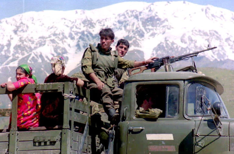 Des gardes-frontières russes, près de la frontière entre le Tadjikistan et l'Afghanistan, emmènent des femmes tadjikes dans le village voisin de Kalay-Khumb à l'arrière de leur camion, le 21 mai 1994. (Photo par EPA / AFP)