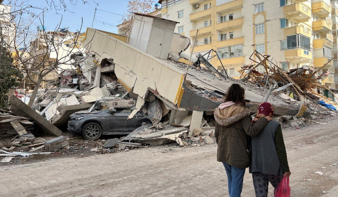 Des femmes passent devant un immeuble résidentiel effondré à la suite d'un tremblement de terre meurtrier en Turquie. (Photo, REUTERS)
