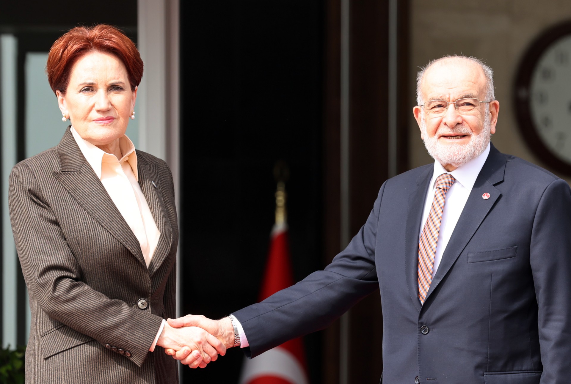 La présidente du Parti Iyi, Meral Aksener (à gauche), et le président du Parti de la Félicité (SP), Temel Karamollaoglu (à droite), se serrent la main alors qu'ils posent pour la presse avant leur réunion à Ankara, le 2 mars 2023. (Photo par Adem Altan / AFP)