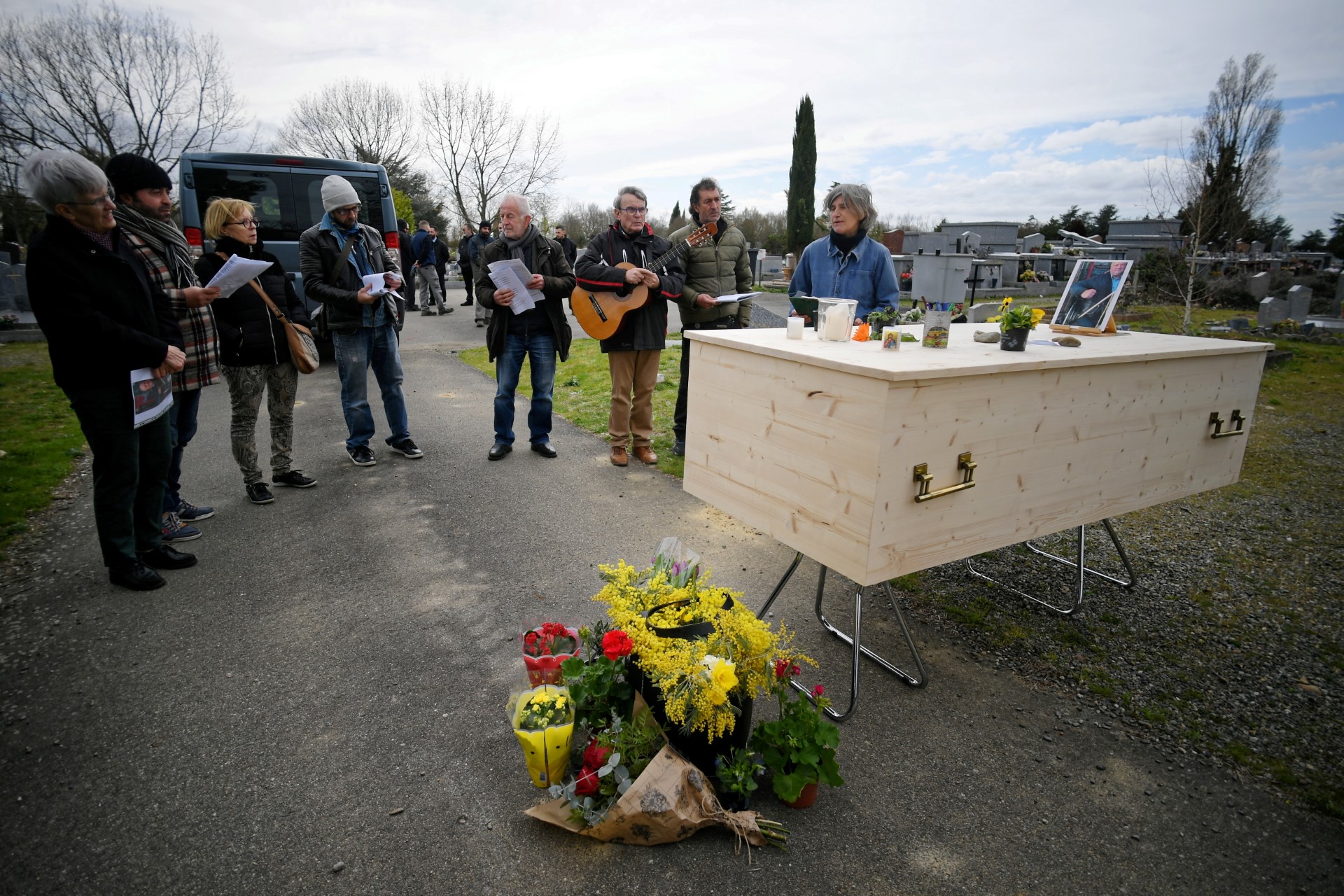 Des membres de la chorale "Choeur Kokeliko" chantent lors de la cérémonie funéraire de Benjamin, un sans-abri, organisée par l'association caritative "Goutte de Vies" dans le cimetière de Cornebarrieu, près de Toulouse, dans le sud-ouest de la France, le 17 mars 2023. (Photo Valentine CHAPUIS / AFP)