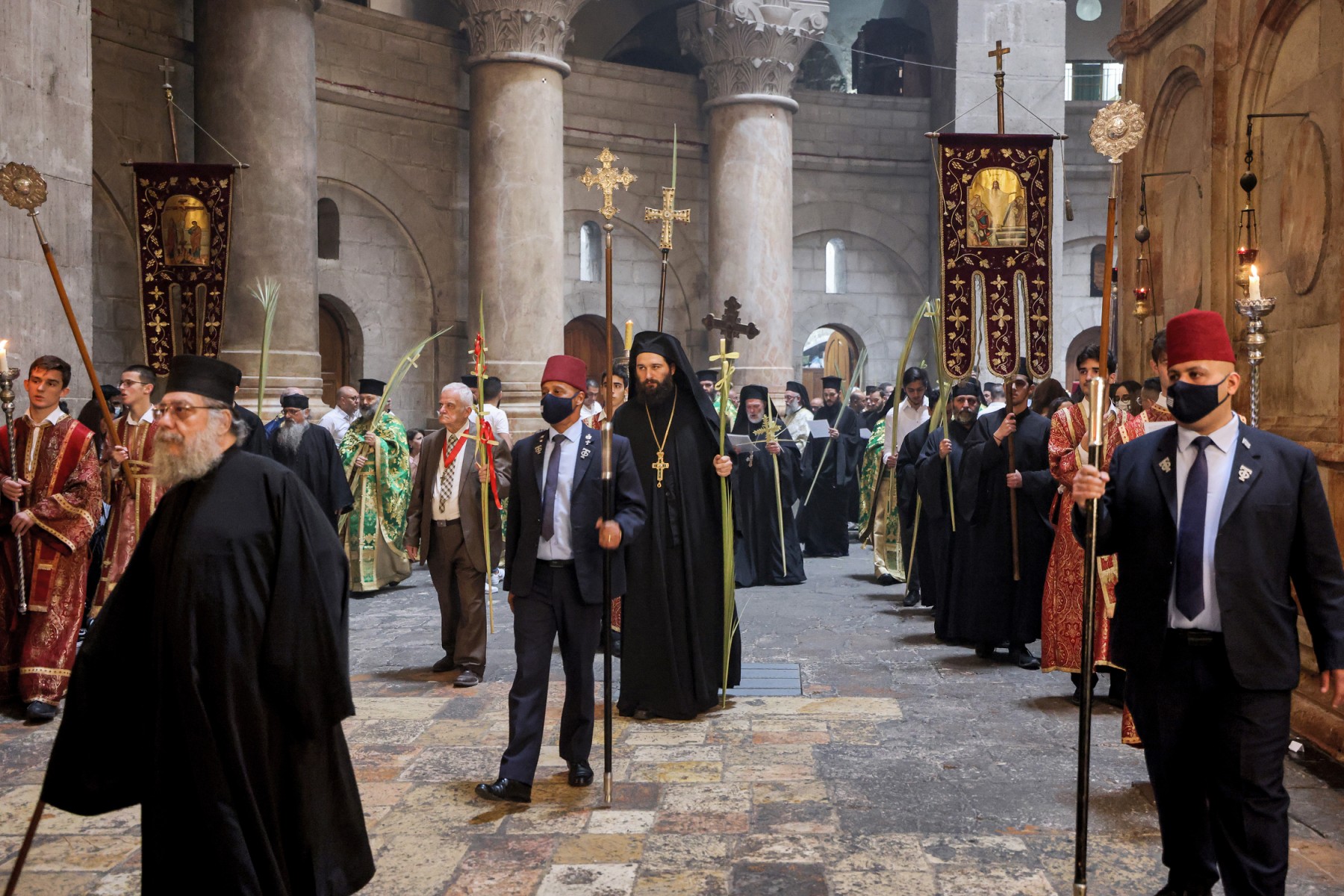 Des religieux orthodoxes grecs marchent en procession autour de l'Edicule, le lieu supposé où Jésus-Christ a été enterré, pendant les célébrations du dimanche des Rameaux à l'église du Saint-Sépulcre à Jérusalem, le 25 avril 2021. ( AFP / Emmanuel DUNAND)