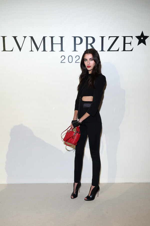 La star a choisi comme accessoires des mitaines noires, des talons assortis et un sac à main rouge pour une touche de couleur (Getty Images)