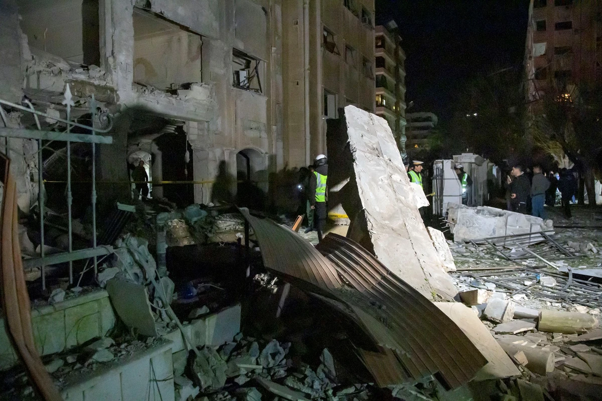 Cette photo distribuée par l’agence officielle SANA, le 19 février 2023, montre des gens constatant les dégâts suite à un tir de missile israélien visant des Iraniens et des membres du Hezbollah. (AFP)