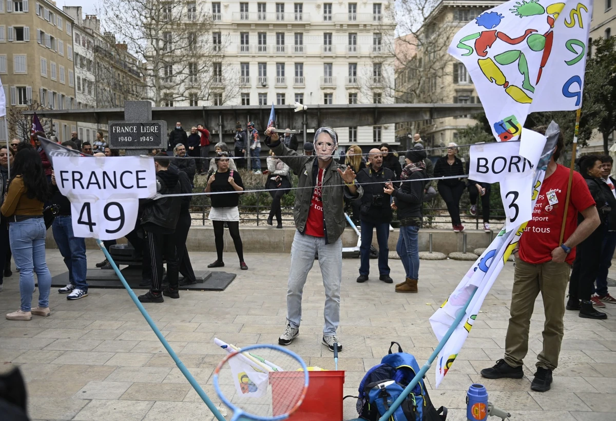 Un manifestant, portant un masque représentant la Première ministre française Elisabeth Borne, participe à une manifestation à Marseille, dans le sud de la France, le 18 mars 2023, deux jours après que le gouvernement français a fait passer une réforme des retraites au Parlement sans vote, en utilisant l'article 49.3 de la Constitution. (Photo par Clement Mahoudeau / AFP).