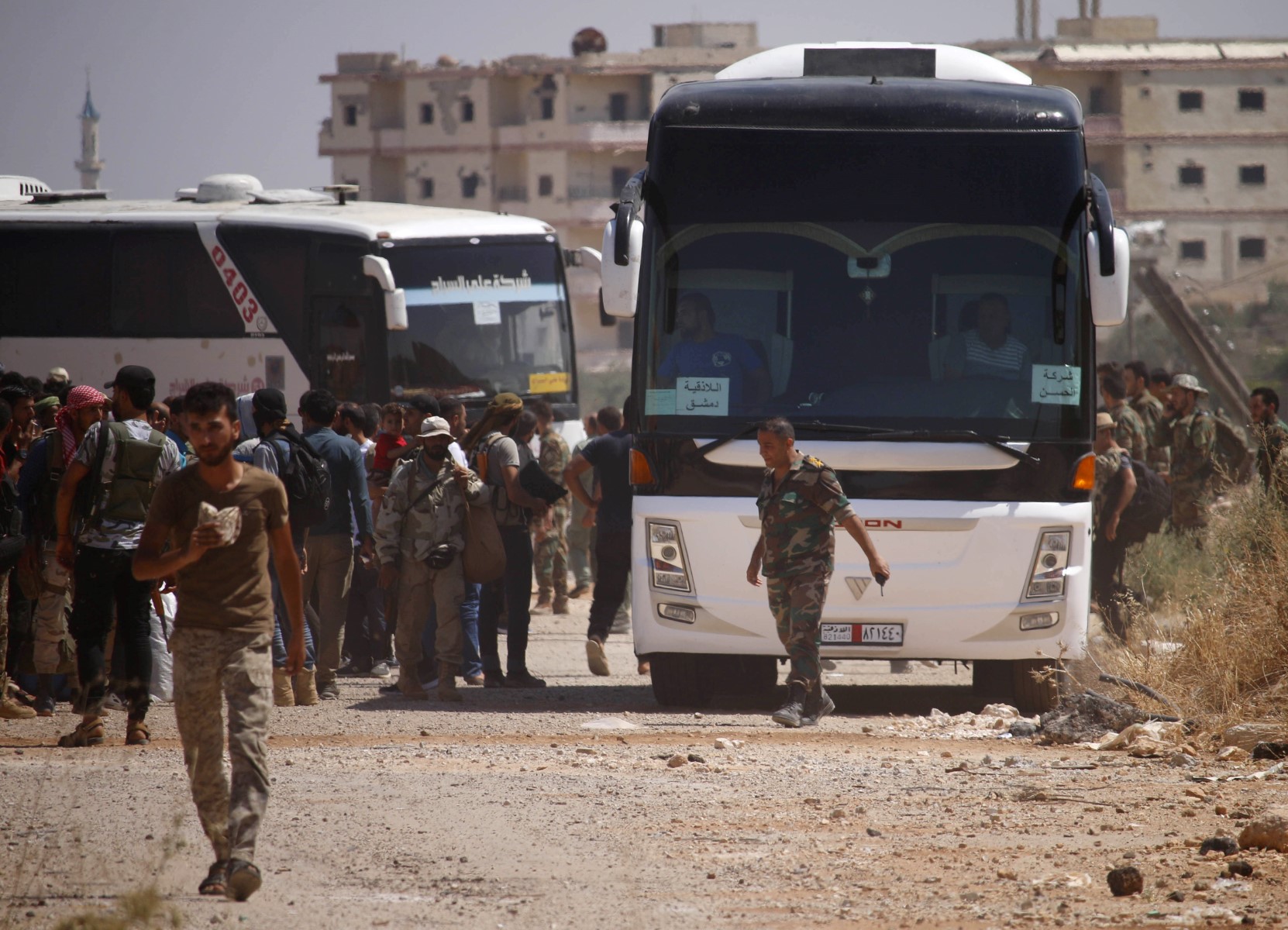 Des rebelles syriens montent dans des bus lors de l'évacuation de la ville de Daraa, le 15 juillet 2018, alors que les forces gouvernementales syriennes ont lourdement bombardé la province voisine de Quneitra, réalisant une avancée terrestre dans la zone. (Photo de Mohamad ABAZEED / AFP)