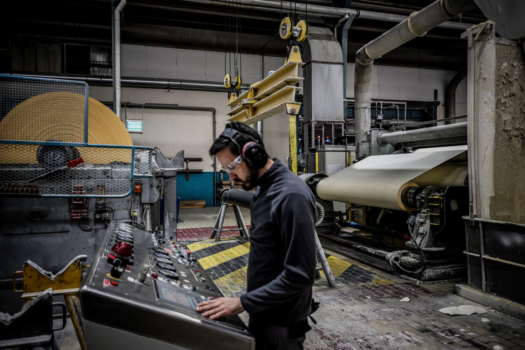 Un homme travaille sur la machine numéro 4 de l'usine "Papeterie du Leman" le 12 décembre 2022 à Publier, lors du processus de production du "papier bible", utilisé pour la production des livres de la collection Pléiade, de la maison d'édition Gallimard (Photo JEFF PACHOUD / AFP)
