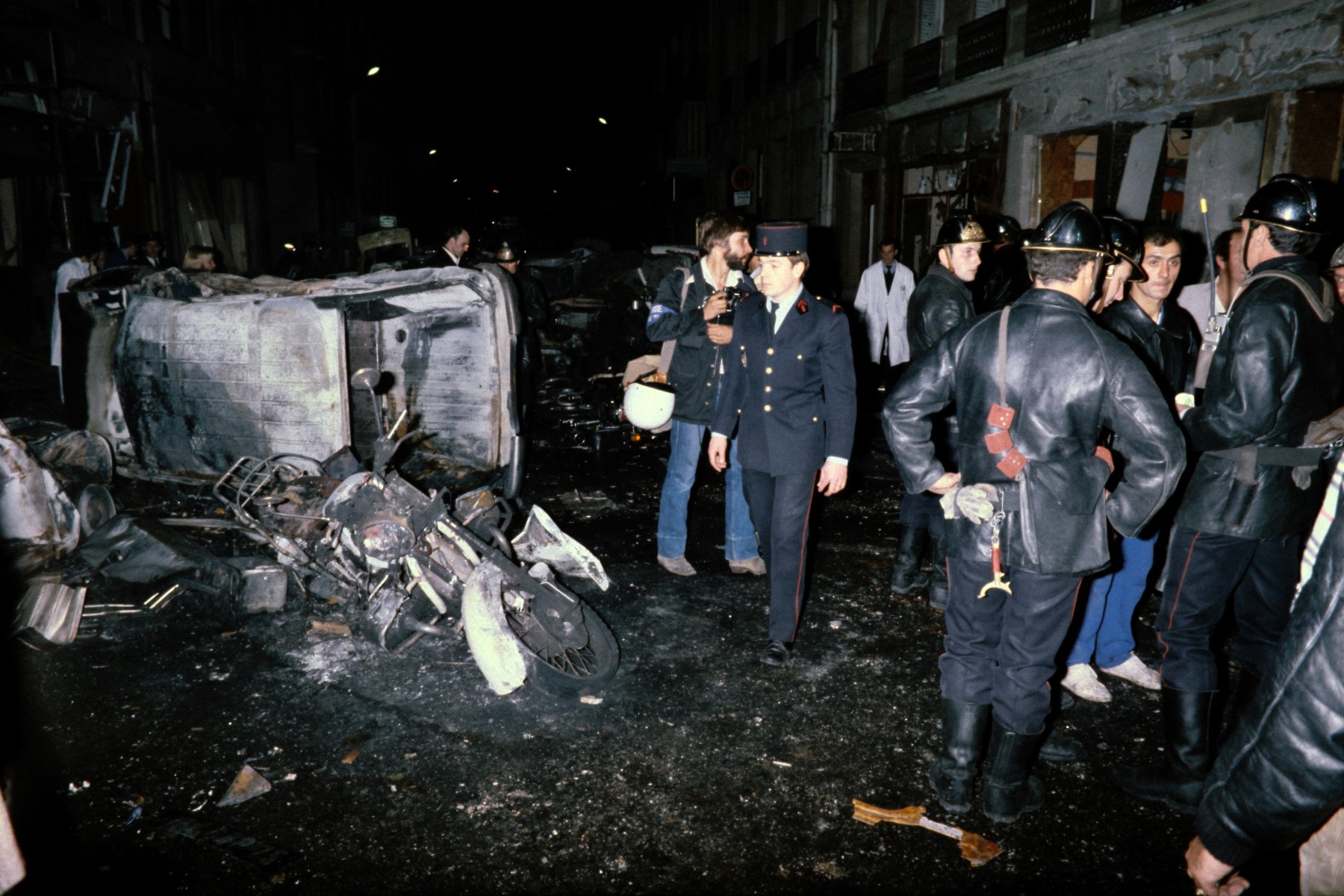 Sur cette photo d'archive prise le 3 octobre 1980, des membres de l'équipe de secours se tiennent au milieu de débris de voitures après l'explosion d'une bombe à la synagogue de la rue Copernic à Paris. (Photo Georges GOBET / AFP)