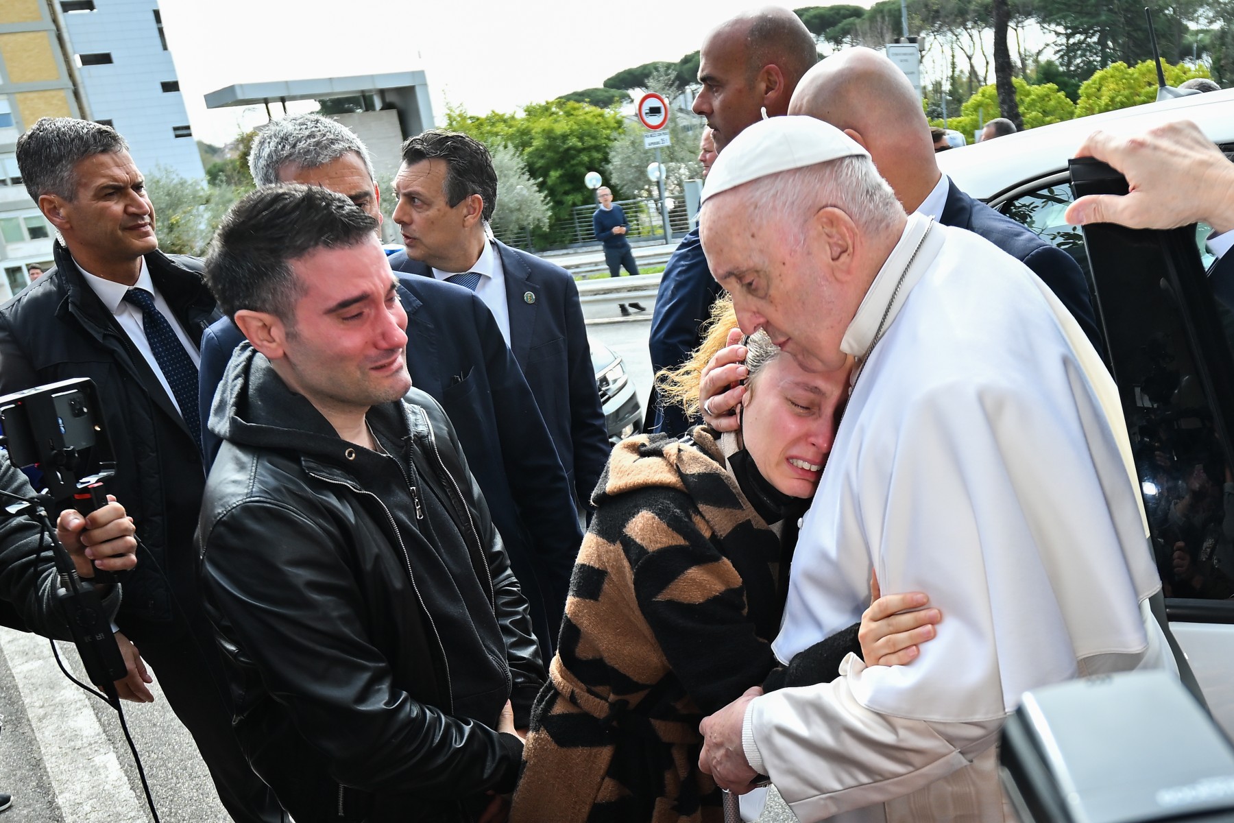 Le pape François serre Serena Subania dans ses bras, sous les yeux de son mari Matteo Rugghia (à gauche), un couple qui a perdu son enfant de cinq ans un jour plus tôt, alors que le pape quitte l'hôpital Gemelli le 1er avril 2023 à Rome. (Photo Filippo MONTEFORTE / AFP)
