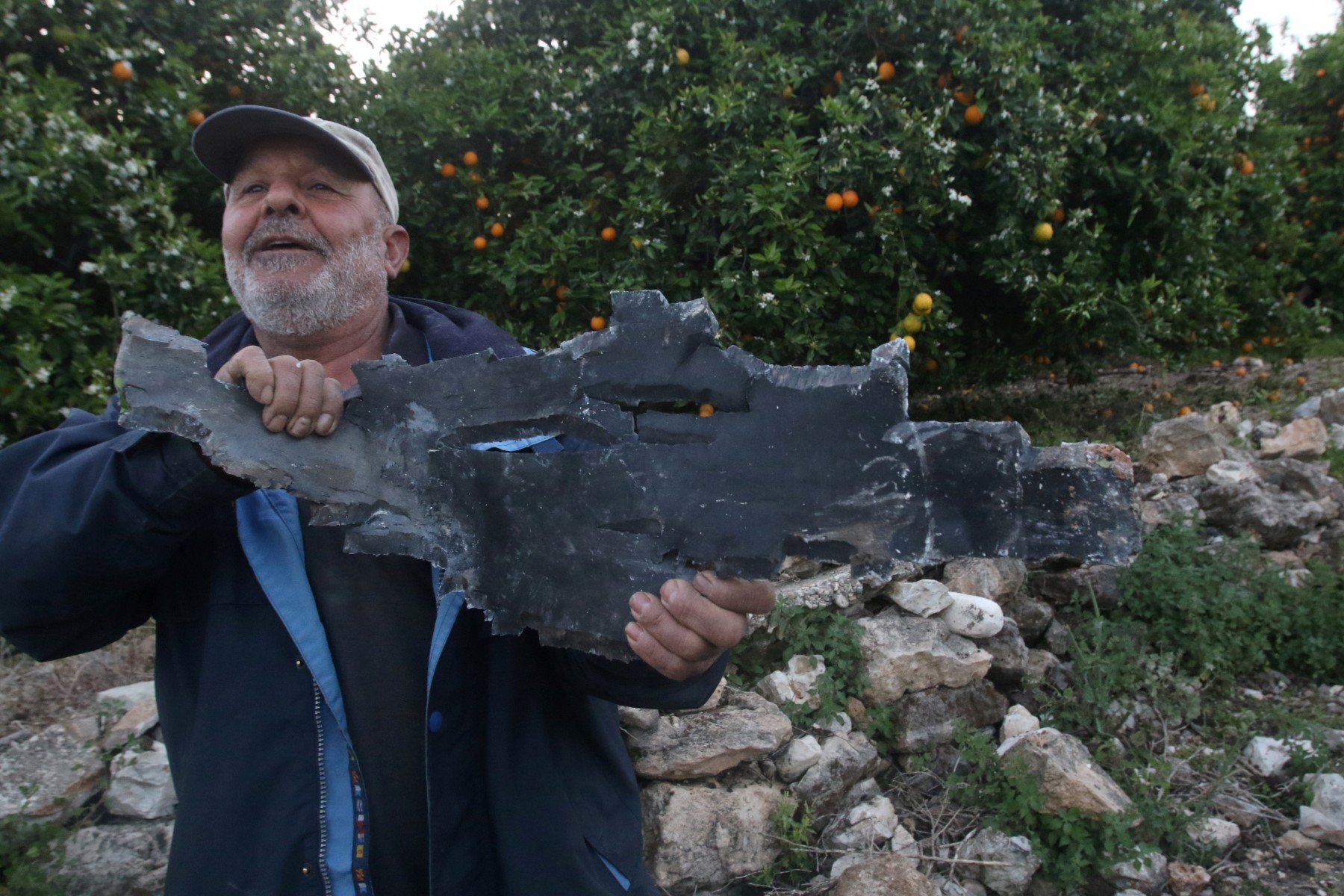 Un homme tient un éclat de roquette après des frappes aériennes israéliennes à Al Qulaylah, à la périphérie de la ville de Tyr, au sud de la capitale libanaise Beyrouth, le 7 avril 2023. (Photo par Mahmoud Zayyat / AFP)