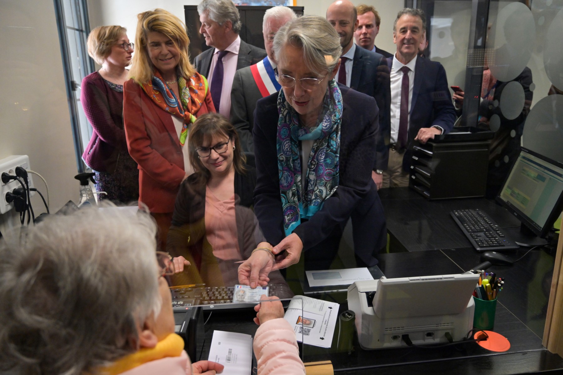 La Première ministre française Elisabeth Borne (au centre) remet une carte d'identité à la mairie de Valençay, dans le centre de la France, le 21 avril 2023. (Photo Guillaume Souvant / AFP)